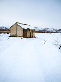 Built structure on snow covered land against sky