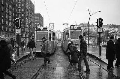 People crossing tramway in city