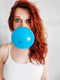 Portrait of woman blowing balloon