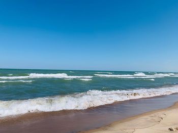 Scenic view of beach against clear blue sky