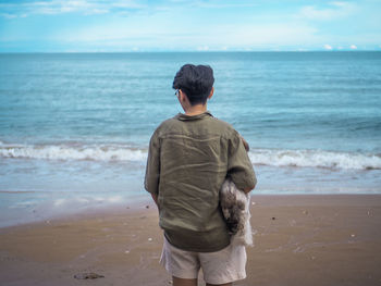 Rear view of man standing on beach