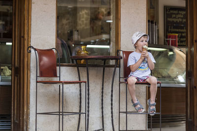 Man eating ice cream while sitting at sidewalk cafe