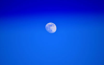 Low angle view of moon against blue sky