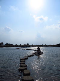 Man on boat in lake against sky