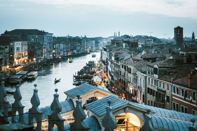 Aerial view of illuminated city against sky at dusk