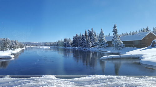 Snow covered landscape against blue sky