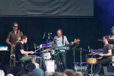 People playing guitar at music concert