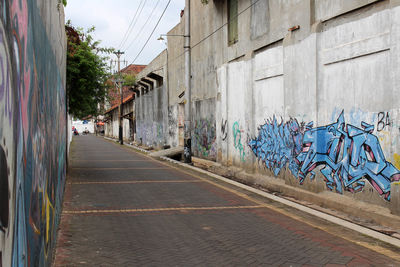 Empty road amidst buildings in city