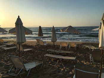 Chairs on beach against clear sky