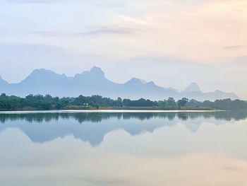 Scenic view of lake by mountains against sky