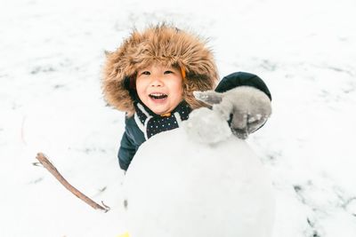 Portrait of woman with dog on snow