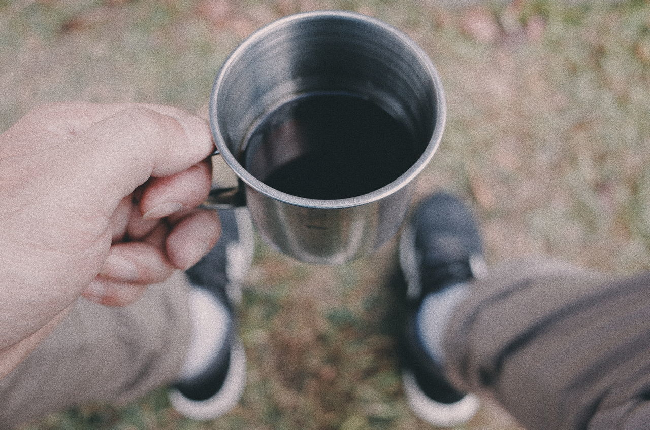 coffee cup, coffee - drink, drink, refreshment, human hand, human body part, cup, real people, food and drink, holding, drinking, one person, human finger, personal perspective, leisure activity, beverage, close-up, disposable cup, human leg, day, men, outdoors, low section, freshness, lifestyles, people