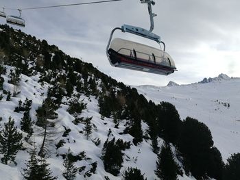 Overhead cable car over snowcapped mountains against sky