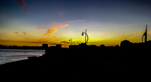 Silhouette city against sky during sunset