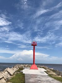 Lighthouse by sea against sky