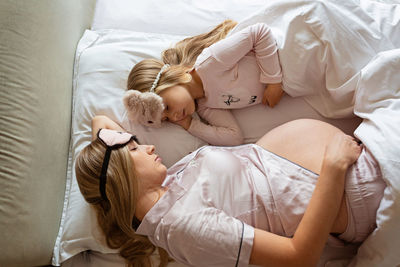 High angle view of mother and daughter on bed at home