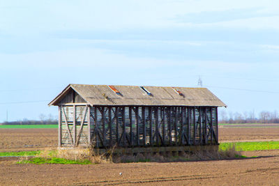 Barn on field against sky