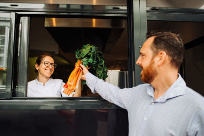 Female chef receiving delivery of vegetables to restaurant