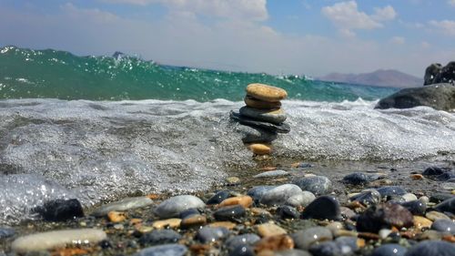 Surface level of stones on beach against sky