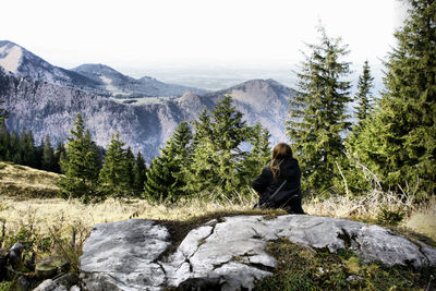 Woman sitting on rock in forest