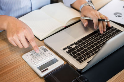 Midsection of woman using laptop on table