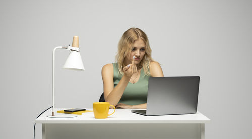 Portrait of woman using laptop on table