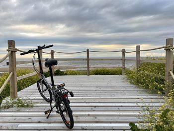 Bicycle on pier against sky