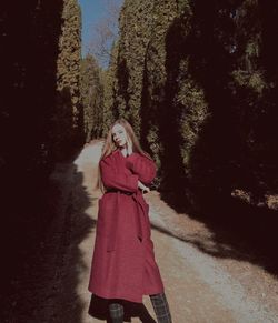 Portrait of woman standing by tree