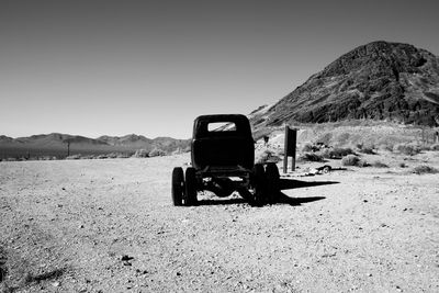 Tractor in desert against clear sky