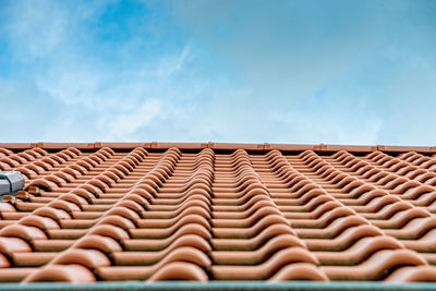 Low angle view of roof tiles against sky