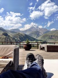 Low section of man in mountains against sky