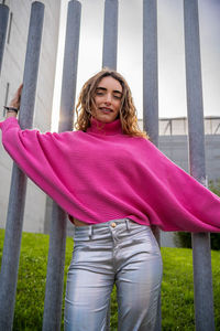 Portrait of young woman standing against trees