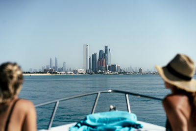 Rear view of woman in sea against clear blue sky