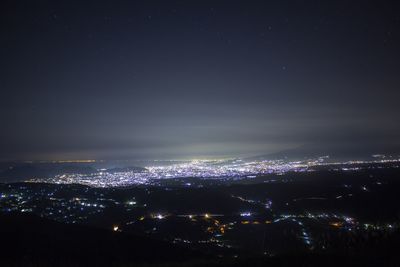 Illuminated cityscape against sky at night