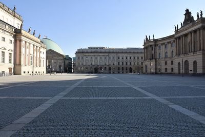 Buildings in city against clear blue sky