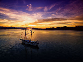 Boat sailing on sea against sky during sunset