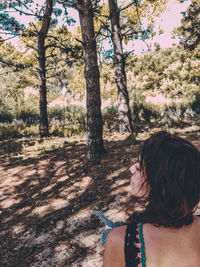 Rear view of woman standing amidst trees