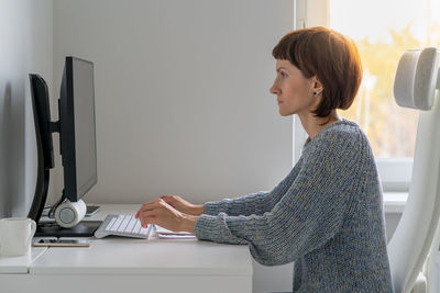 Side view of businesswoman working in office