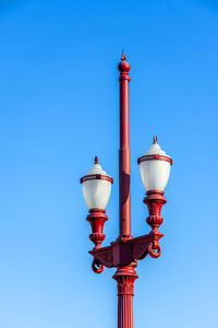 Old red street lamp with blue sky in the background in belo horizonte, minas gerais, brazil