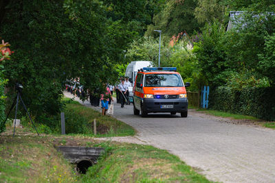 Vehicles on road by trees in city