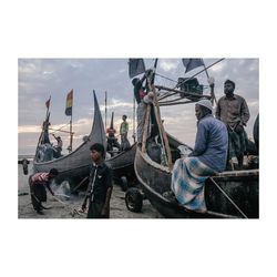 People on boat in sea against clear sky