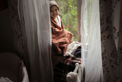 Toddler girl with a cat sitting on the window, concept of a fabulous childhood and favorite animals