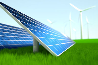 Close-up of wind turbines on field against clear sky