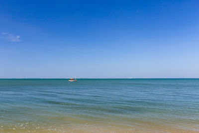 Scenic view of sea against blue sky