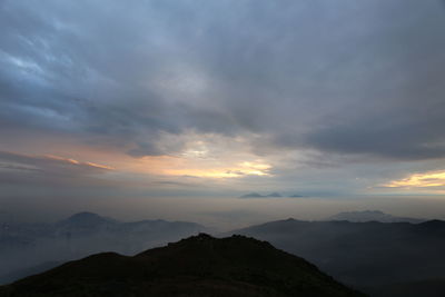 Scenic view of mountains against cloudy sky