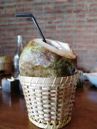 Close-up of drink in basket on table against wall