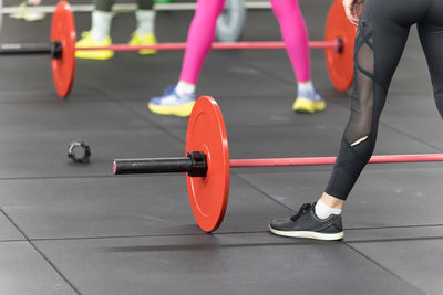 Fitness workout at gym- girls doing exercises in class with barbells