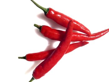 Close-up of red chili peppers against white background