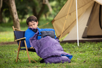 Portrait of young man sitting in tent