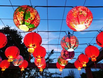 Low angle view of illuminated lanterns hanging against sky at night